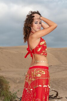 해질녘 사막 모래 언덕에서 배꼽 춤을 추는 아랍 여성