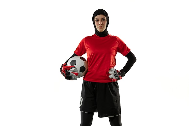 Arabian female football player, goalkeeper on white studio wall