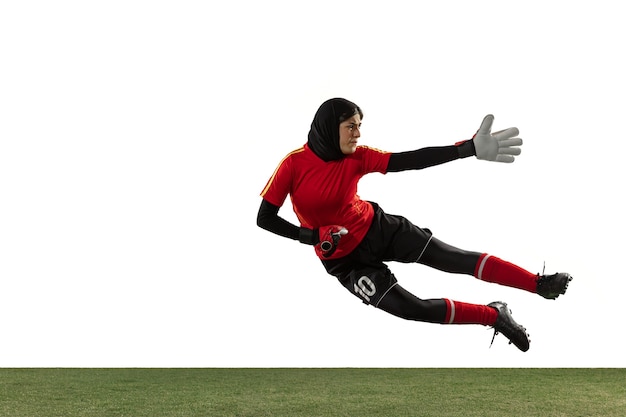 Arabian female soccer or football player, goalkeeper on white studio background.