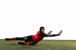 Бесплатное фото Арабский женский футбол или футболист, вратарь на белом фоне студии. молодая женщина ловит мяч, тренируется, защищает цели в движении и действиях. понятие о спорте, хобби, здоровом образе жизни.