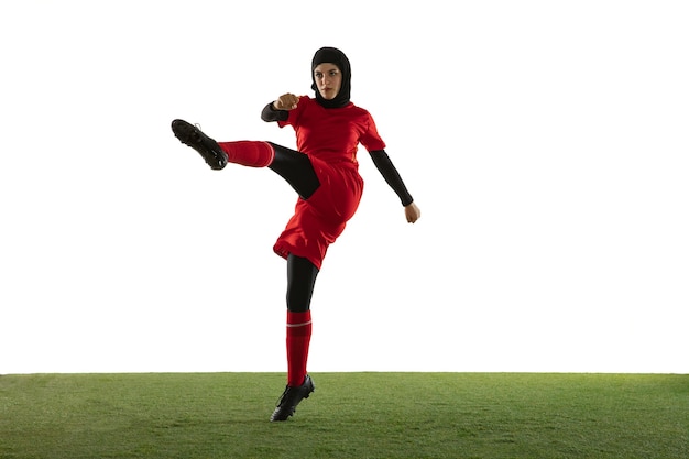 Arabian female soccer player isolated on white studio wall