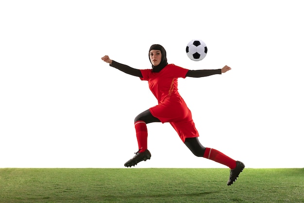 Arabian female soccer player isolated on white studio wall