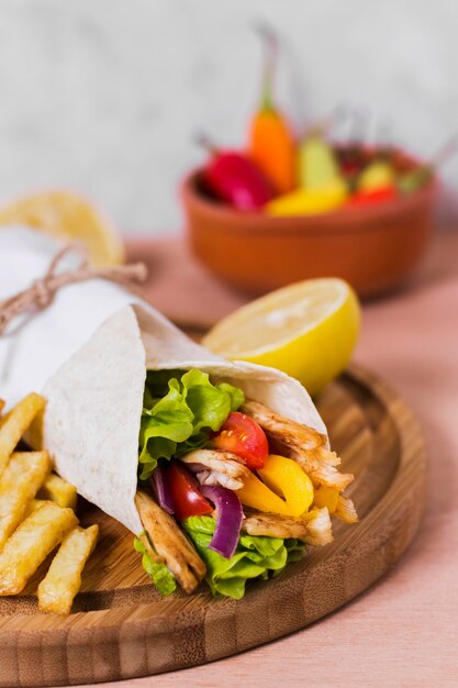 Сэндвич с арабским кебабом, завернутый в белую бумагу, высокий вид