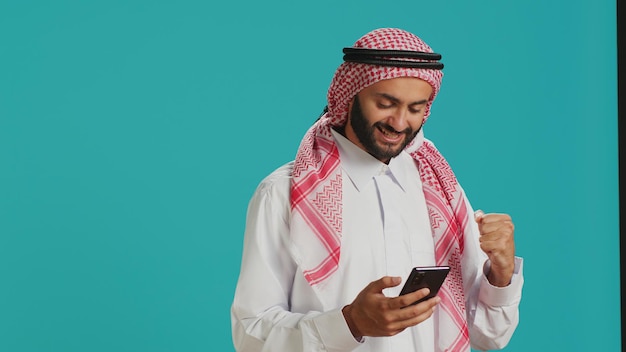 Free photo arabic person holding smartphone in hand