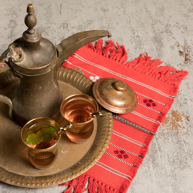 Free photo arabic tea in glasses with teapot on cloth