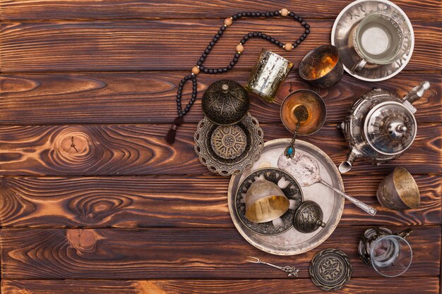 Арабский чайник с чашками и бисером на столе
