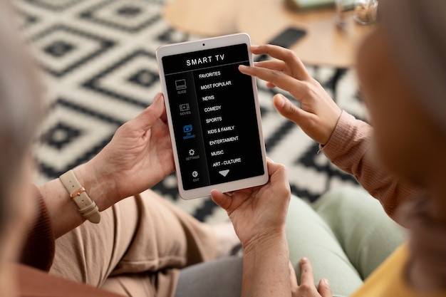 Arabic woman is teaching senior woman to use tablet in living room