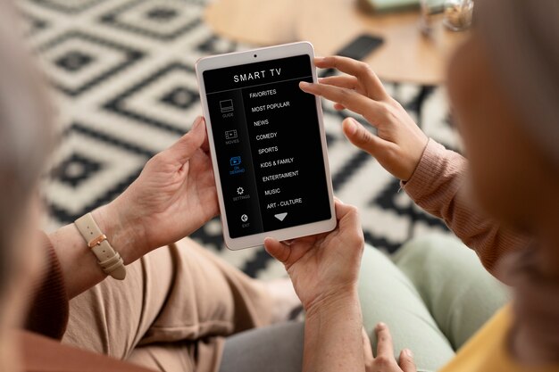 Arabic woman is teaching senior woman to use tablet in living room