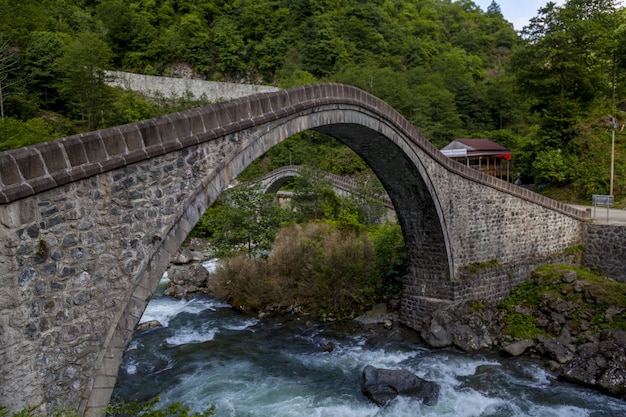 Arch bridge above a river surrounded by forests in Arhavi in Turkey