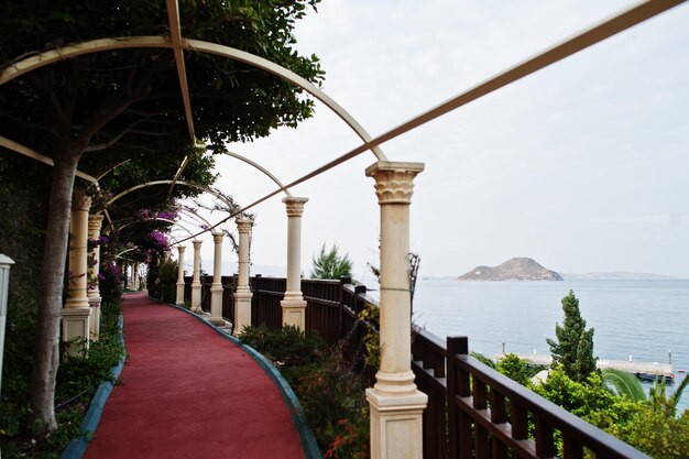 Arch with flowers in Turkey resort against island in sea