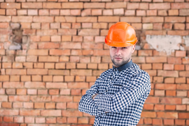 Foto gratuita architetto di fronte al muro di mattoni