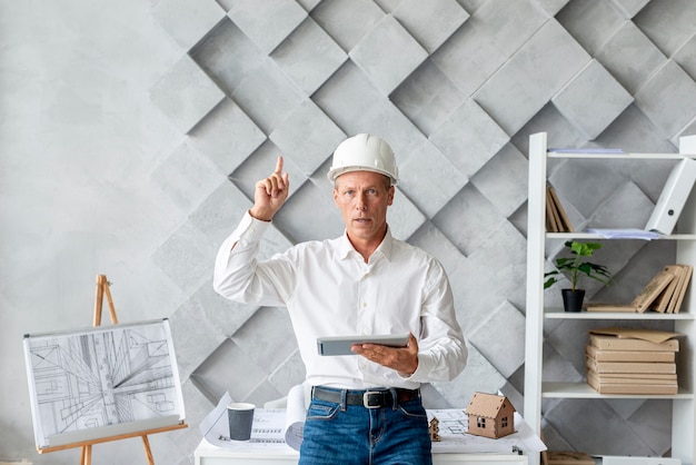 Architect in his office pointing up