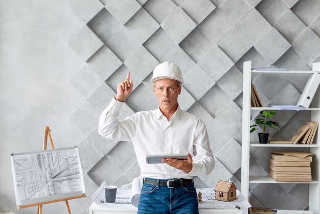 Architect in his office pointing up