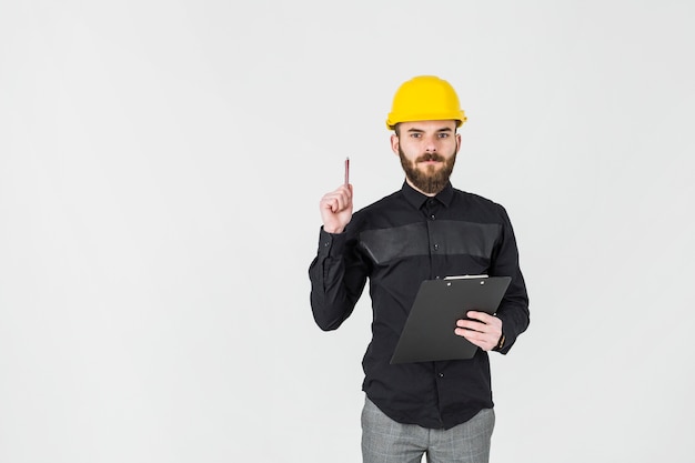 An architect wearing hardhat holding clipboard over white background