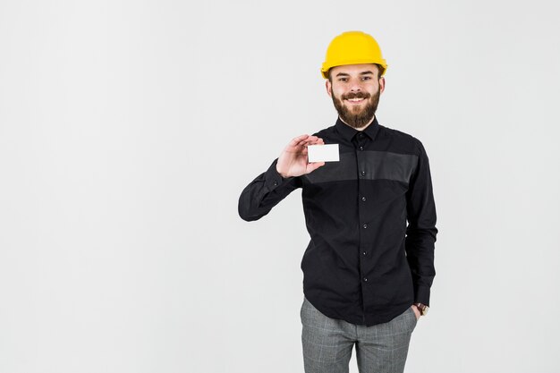 An architect wearing hardhat showing visiting card against white background