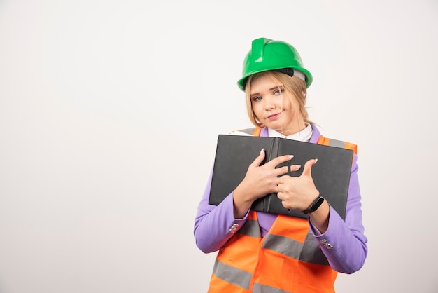 Architect woman in hardhat with tablet on white.