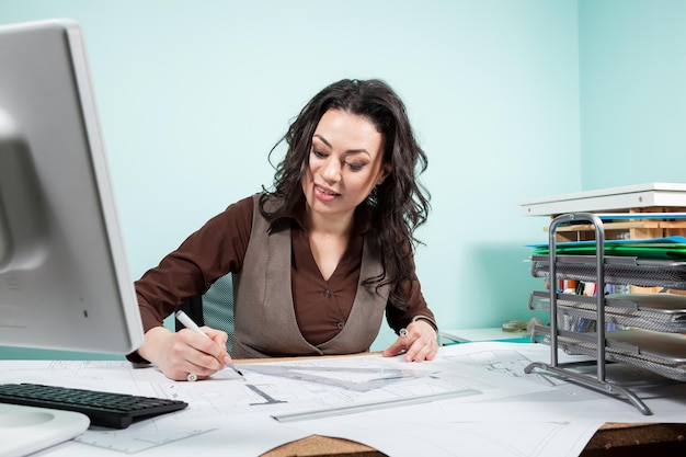 Architect woman in her office with blueprints in front of her. Working on new projects. Architecture and design