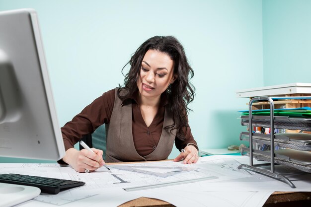 Architect woman in her office with blueprints in front of her. Working on new projects. Architecture and design