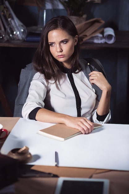 Architect woman working on drawing table in office or home.