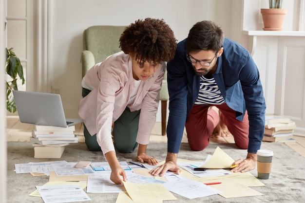 Free photo architects develop future project posing on floor in living room