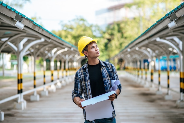 Architects hold the building plan and check the work.