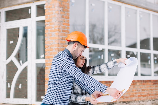 Architects looking at plan in front of house