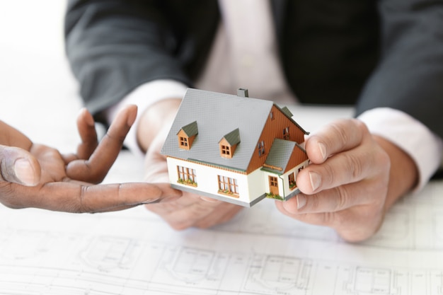 Architecture, building and construction concept. Cropped shot of two engineers evaluating design of new housing project.