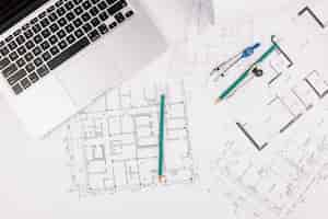 Free photo architecture concept with building plan and laptop