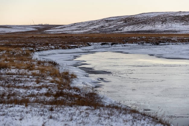 Арктический пейзаж в зимнее время. небольшая река со льдом в тундре.
