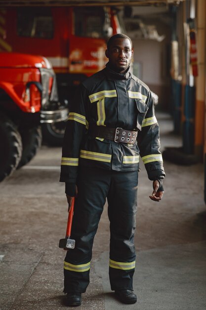 Arfican fireman in a uniform. Man prepare to work. Guy with hummer.