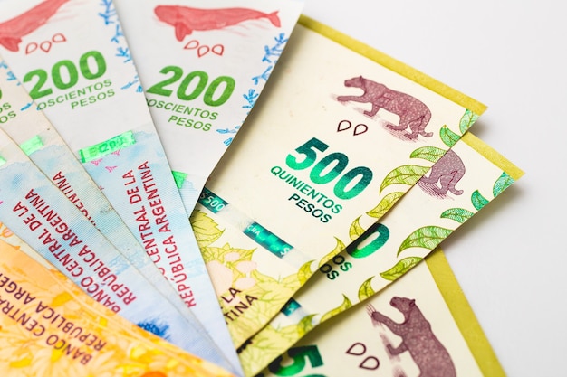 クローズアップ​写真​で​白い​表面​に​アルゼンチン​の​お金​の​紙幣