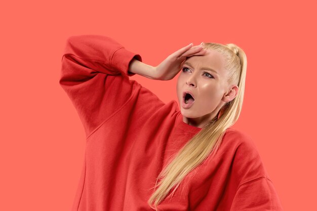 Argue, arguing concept. Beautiful female half-length portrait isolated on coral studio backgroud. Young emotional surprised woman looking at camera.Human emotions, facial expression concept