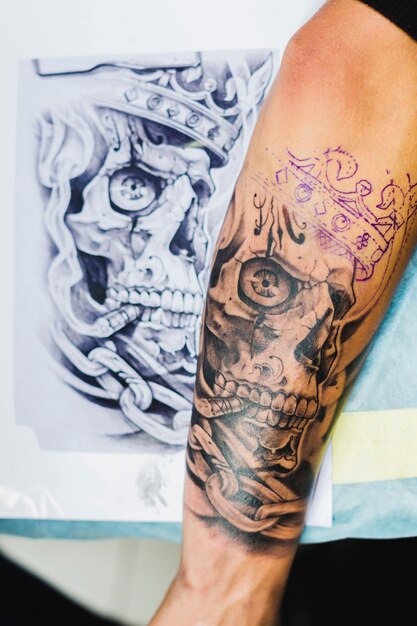 Arm with tattoo near the sketch