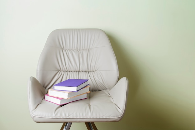 Free photo armchair with three colored books