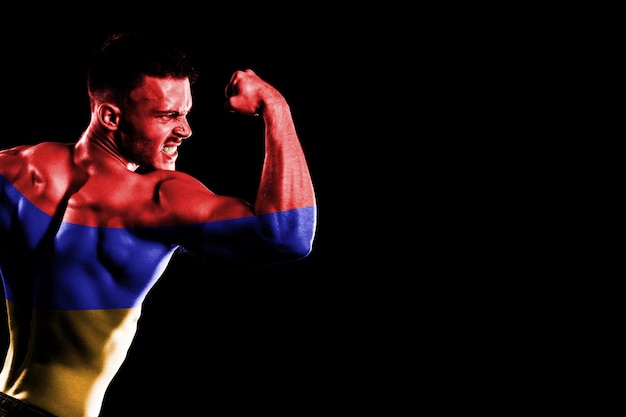 Armenia flag on handsome young muscular man black background