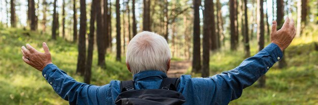 Arms wide open elder man exploring nature