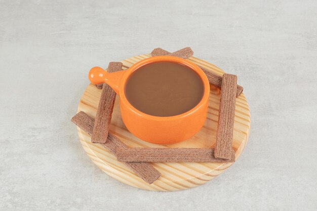 나무 접시에 아로마 커피와 코코아 비스킷.