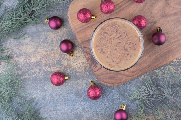 Aroma coffee with Christmas balls on wooden board. High quality photo