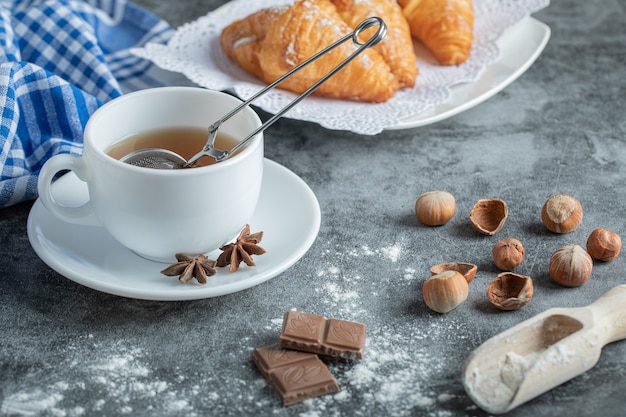 Aroma cup of tea with delicious croissants.