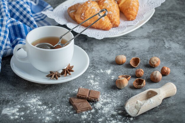 Aroma cup of tea with delicious croissants.