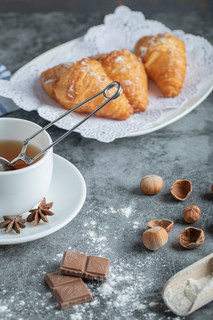 Aroma cup of tea with delicious croissants.
