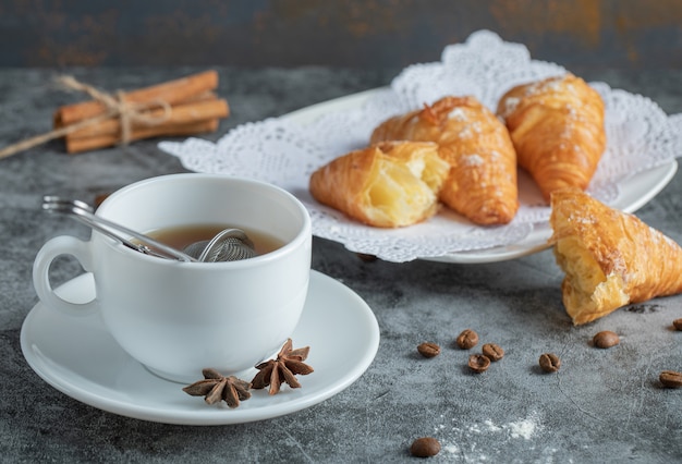 Aroma cup of tea with delicious croissants.