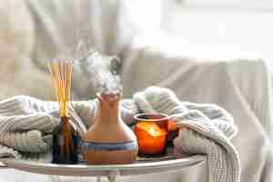 Free photo aroma oil diffuser lamp with the stick perfume knitted element and candle