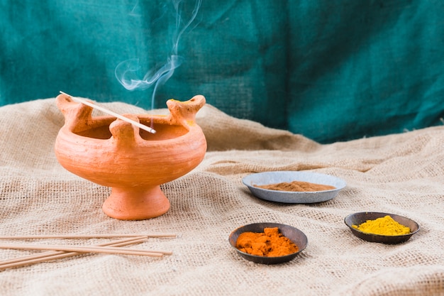 Aroma sticks on bowl near saucers with different spices
