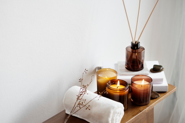 Сервировка стола для ароматерапии ароматическими свечами и полотенцем