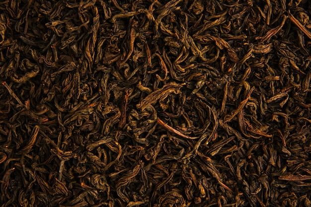 Aromatic dry green tea leaves with close-up.