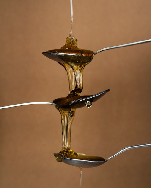 Aromatic honey pouring on spoons