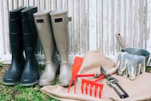 Free photo arranged boots with instruments in garden