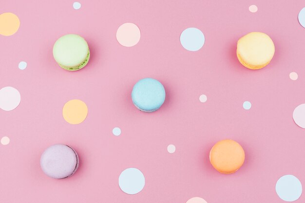 Arranged colorful macaroons with confetti  top view