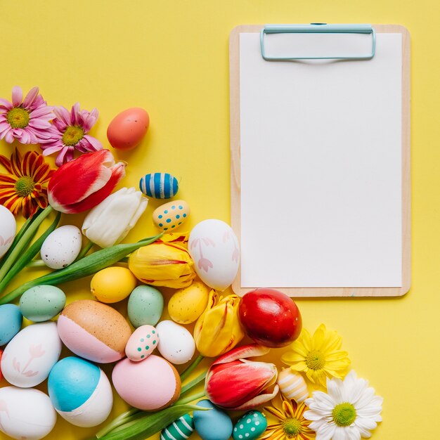 Free photo arranged easter eggs and clipboard